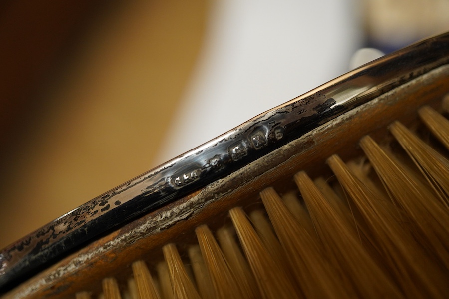 A George V silver six piece engine turned dressing table set Birmingham, 1922 Carringon & Co, comprising hand mirror, pair hairbrushes, pair clothes brushes and a mounted tortoiseshell comb, initialled, in a fitted case